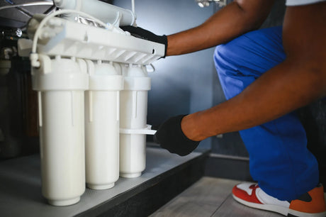 Technician inspecting an under sink RO filter system during maintenance