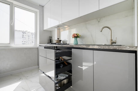 Bright modern apartment kitchen with ample under-sink cabinet space, perfect for installing compact apartment-sized reverse osmosis water filtration units.
