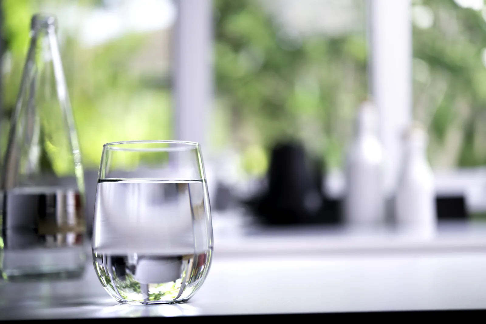  A clear glass of water in a bright home setting, illustrating daily hydration.