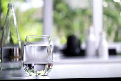  A clear glass of water in a bright home setting, illustrating daily hydration.