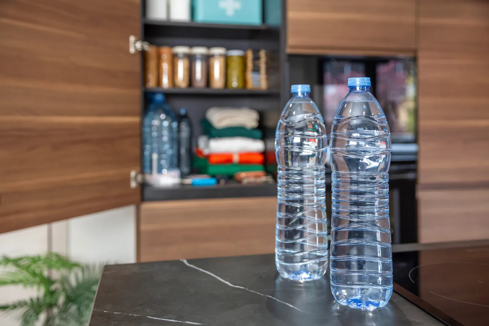 Two plastic water bottles on a counter, representing the reliance on bottled water that sustainable filters aim to replace.