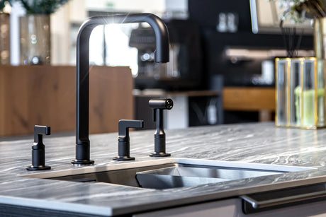 Sleek black kitchen faucet set with matching handles on marble countertop