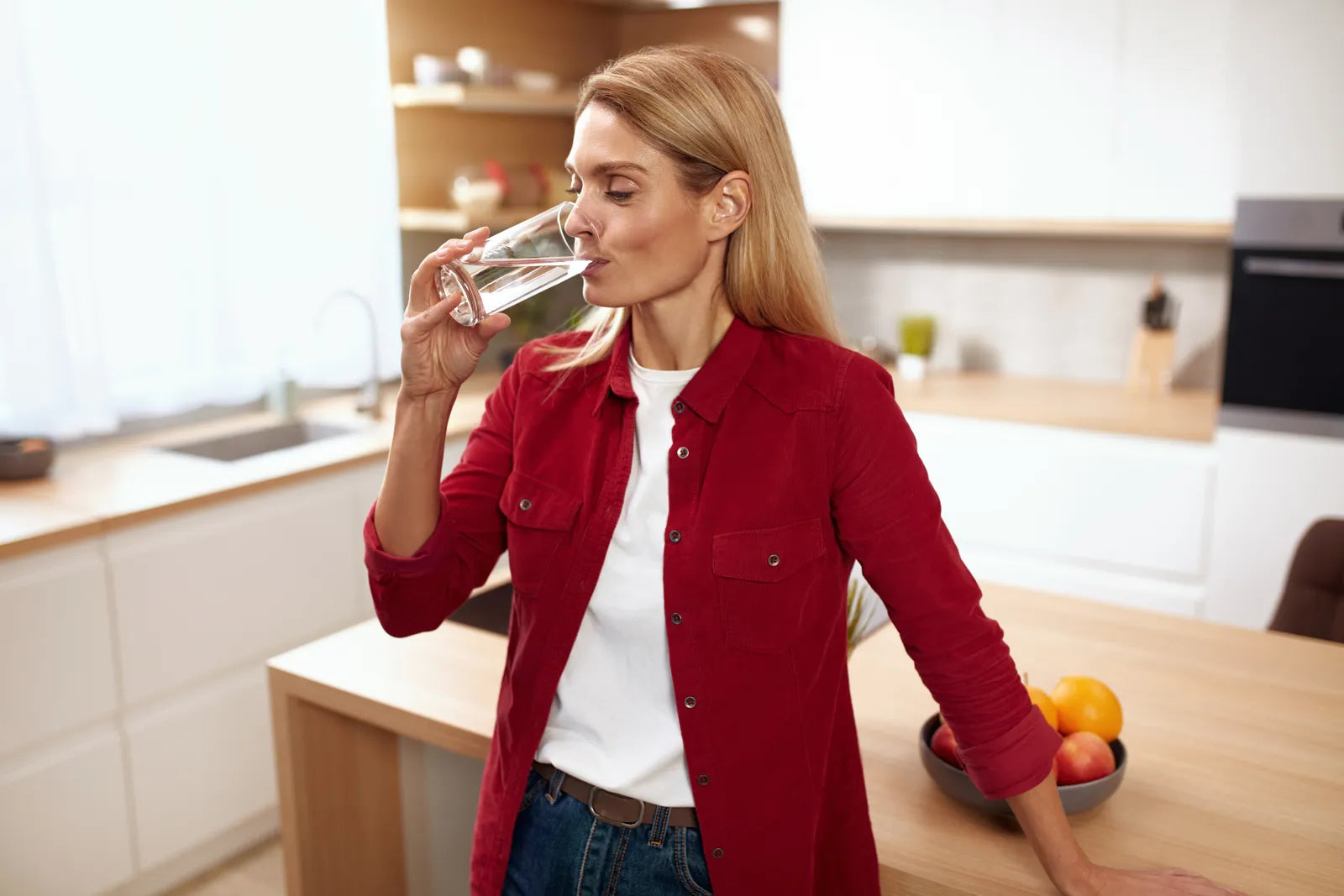 A woman enjoys clean RO water, a key benefit of regular system maintenance.