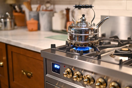 A kettle boiling water on a gas stove, depicting the process of boiling tap water.