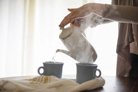 One woman poured boiled water into cups on the table.