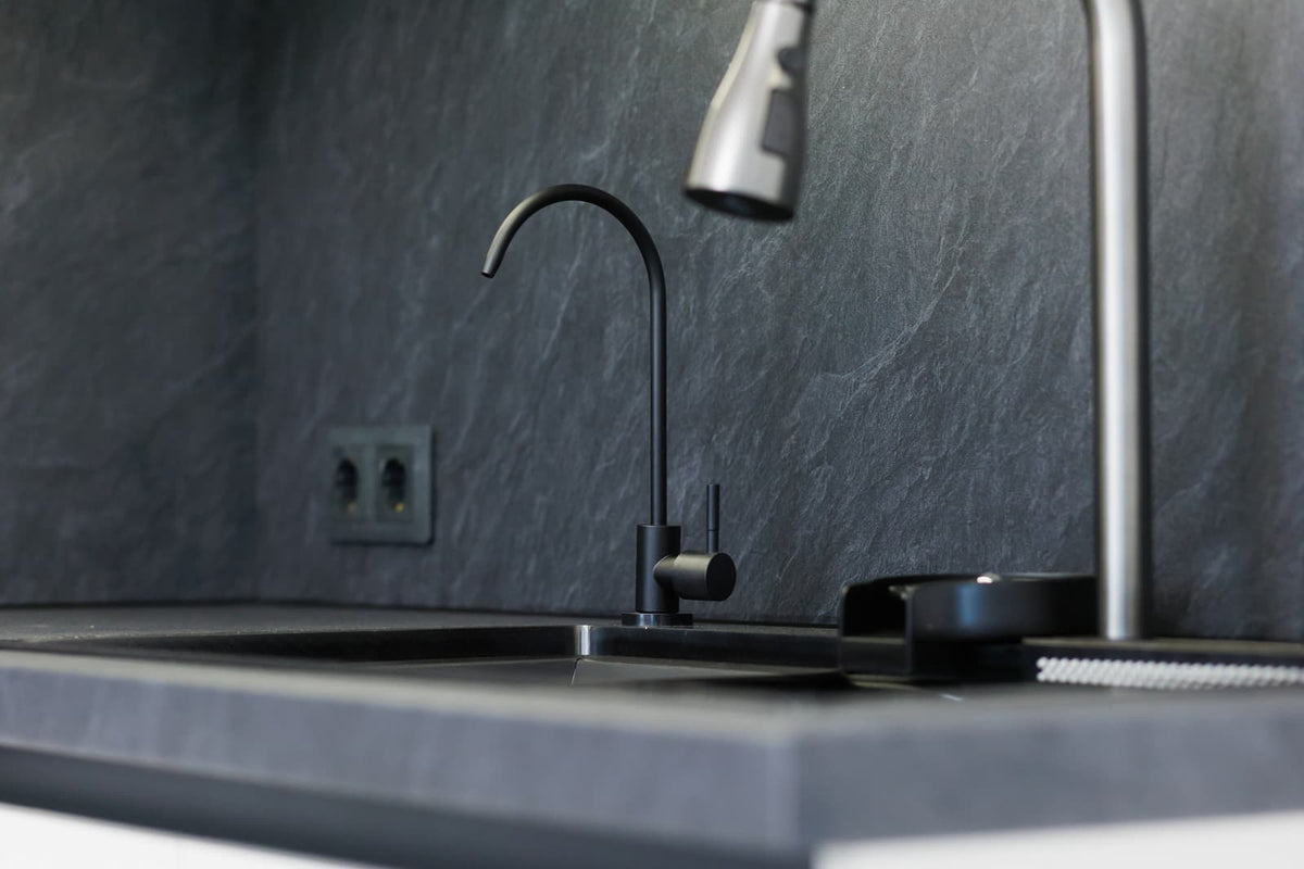 Single kitchen faucet installed at a clean countertop sink with limited accessory-hole space.