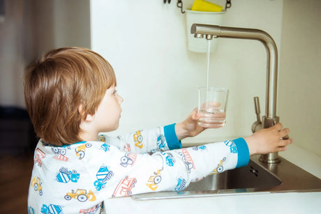 A child uses tap water, illustrating the need for cost-effective RO installation.