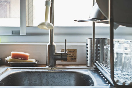 A kitchen sink area prepares for installing a reliable water filter for old houses.